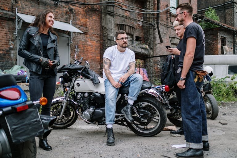 7 Surprising Benefits of Riding a Motorcycle. Casual gathering of motorcyclists socializing in an urban yard with motorcycles.
