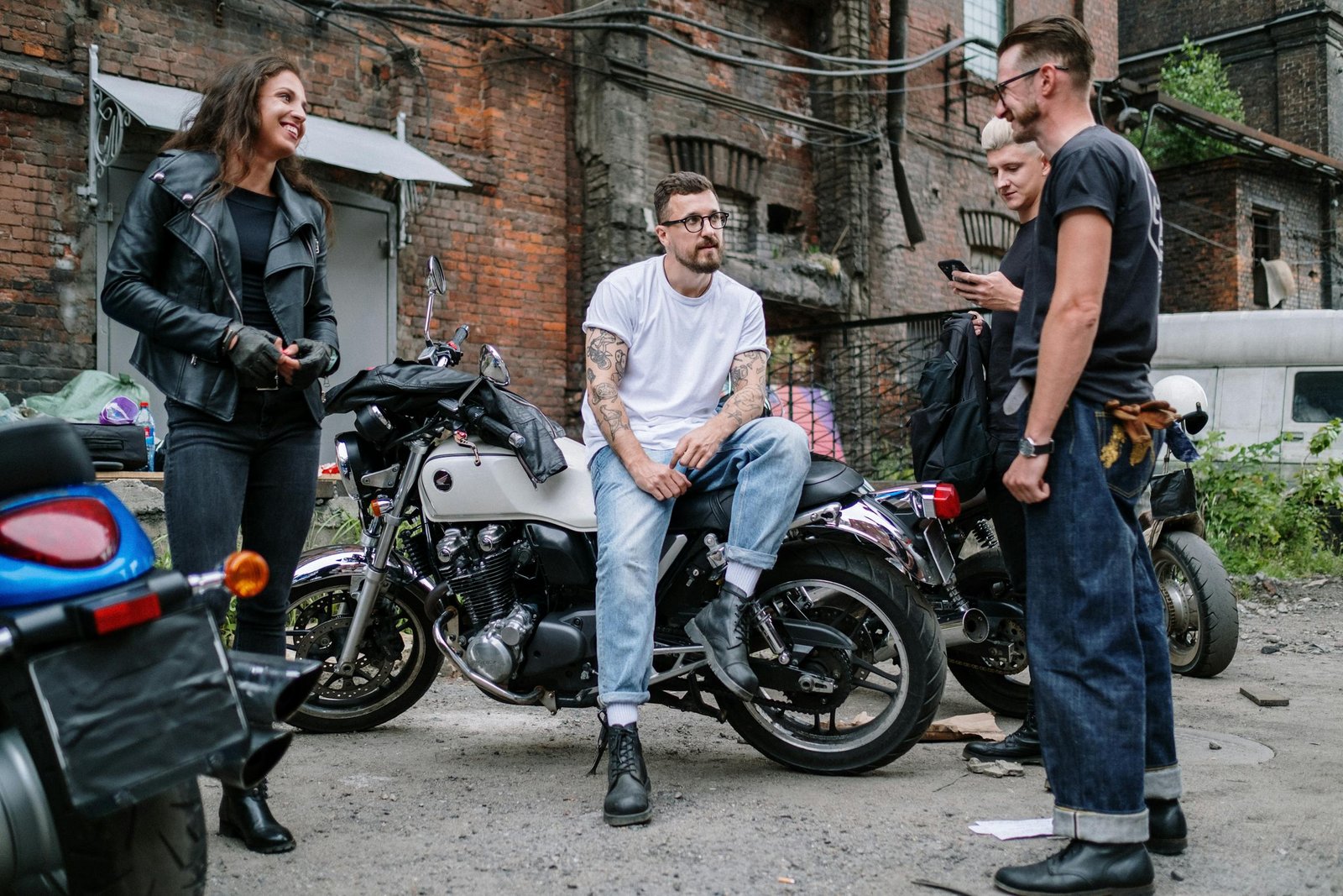 7 Surprising Benefits of Riding a Motorcycle. Casual gathering of motorcyclists socializing in an urban yard with motorcycles.